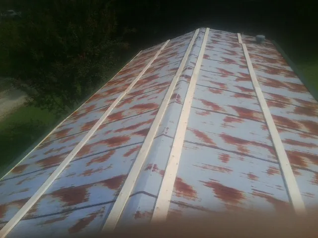 Rusted metal roof panels with new wood purlins before replacement — Storm Damage Roof Repair in Elba by Roofing Brothers