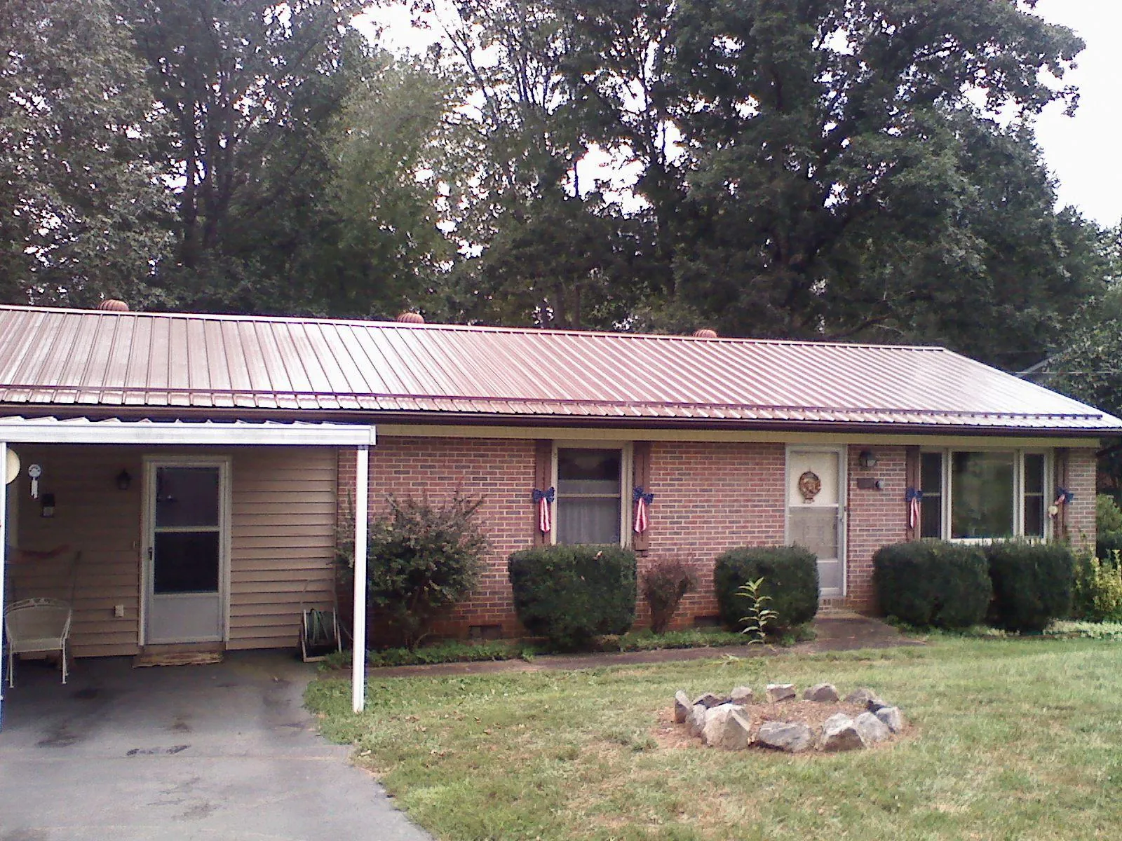 Bronze metal roof and carport on a brick ranch home — Roof Repair work by our crew in Elba